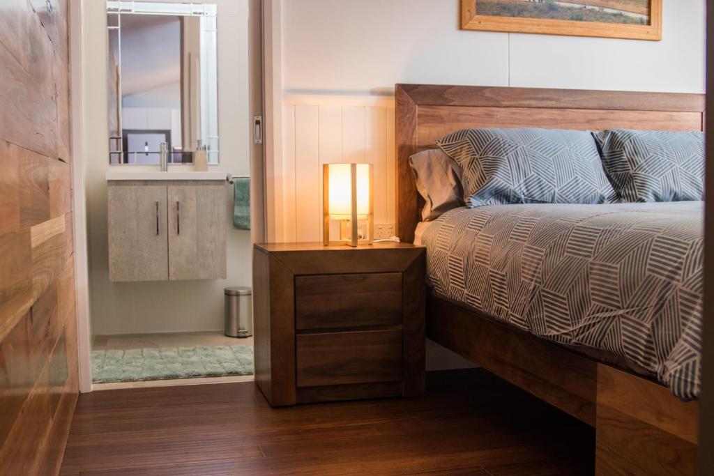 a bedroom with a bed with a lamp on a night stand at Mudgee Apartments on Horatio Street in Mudgee