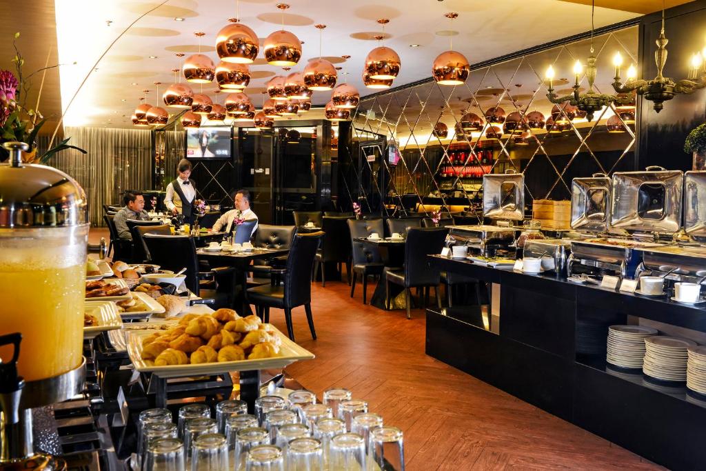 un ristorante con persone sedute ai tavoli con cibo di Horizon Hotel a Kota Kinabalu