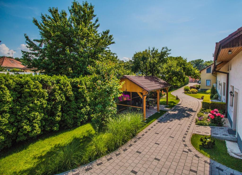 a garden with a gazebo next to a building at Pension Danninger in Piešťany