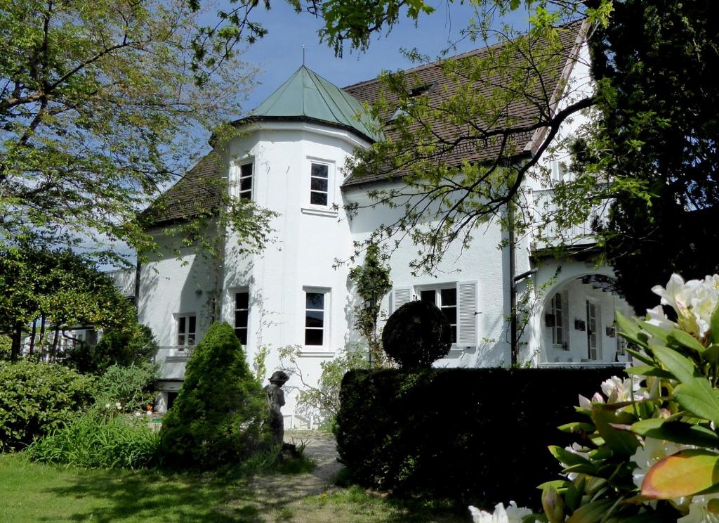 a white house with a green roof at Am Eichholz Galerie & Art-Hotel in Murnau am Staffelsee