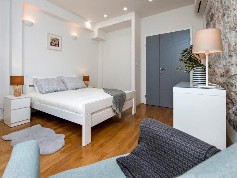 - une chambre avec un lit blanc et une porte bleue dans l'établissement Casa Dora, à Rovinj