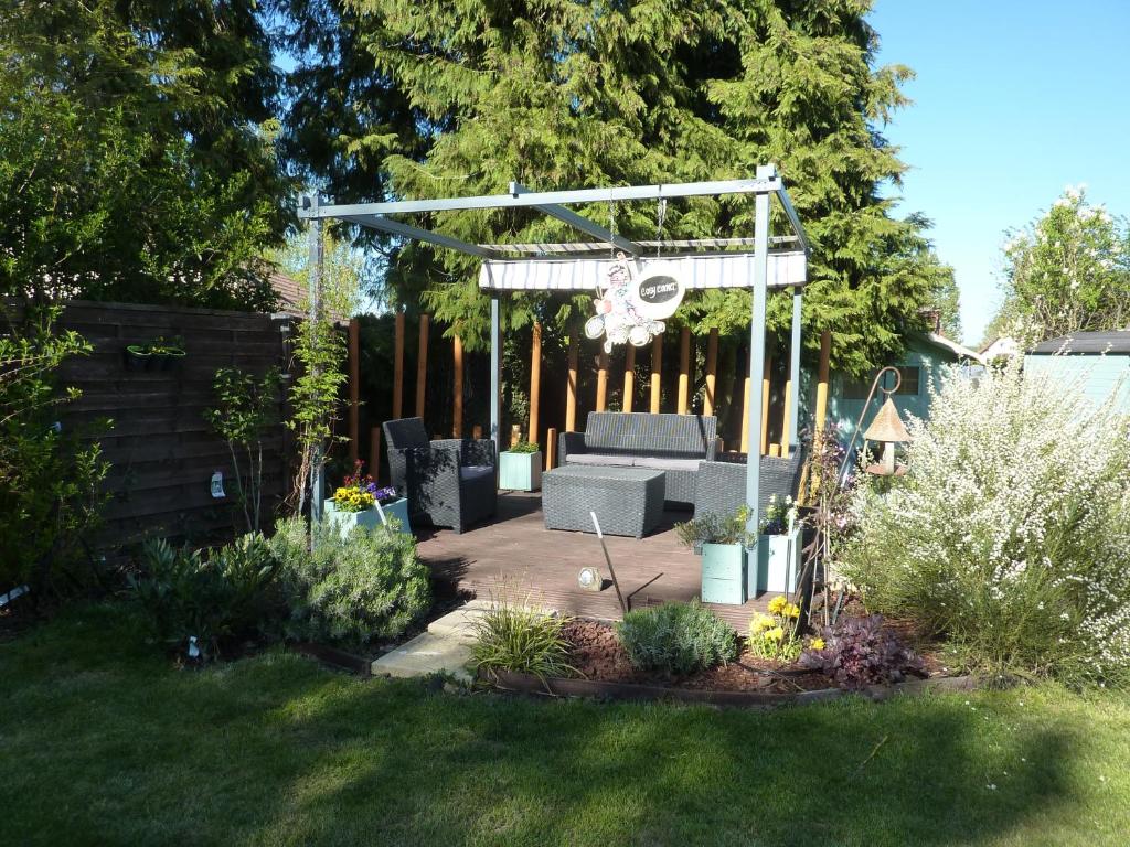 a garden with a bench and a pergola at Lavender Cottage in Chézelles