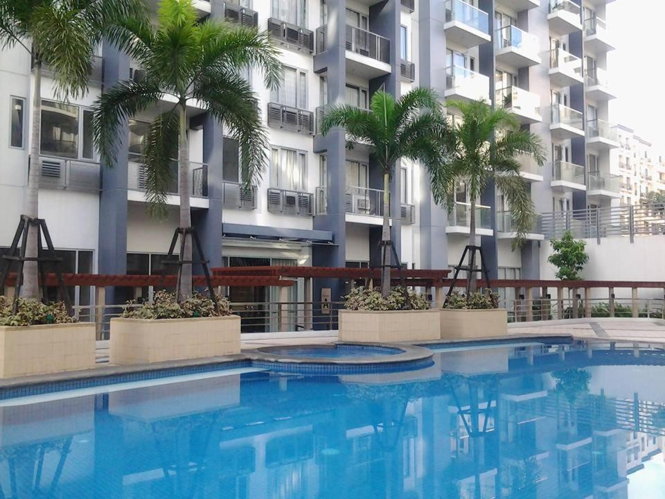 a large swimming pool in front of a building at One Palm Tree Villas in Manila