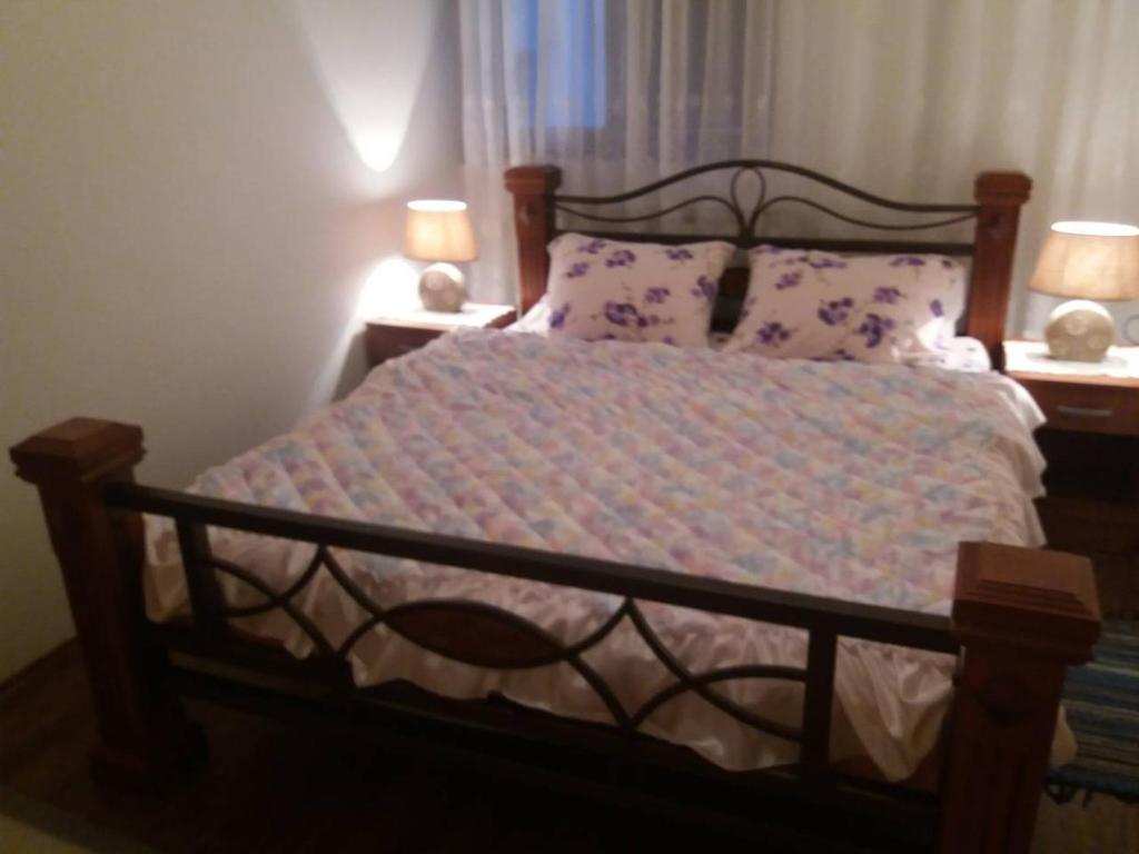 a bed in a bedroom with two lamps and two tables at Apartments Beka in Žabljak