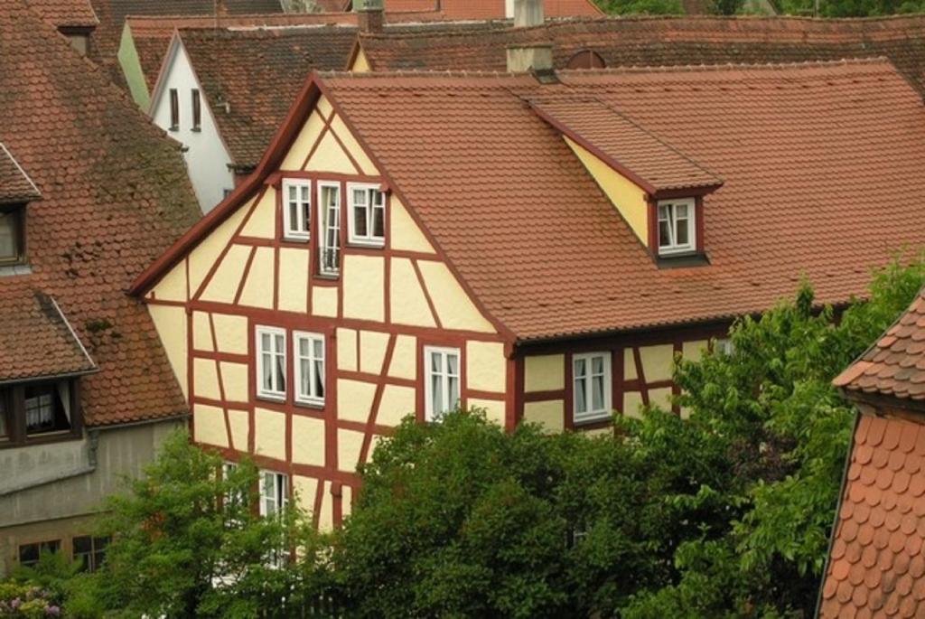 ein gelbes und weißes Haus mit roten Dächern in der Unterkunft "Am Klingentor (EU)" Ferienwohnungen in Rothenburg ob der Tauber