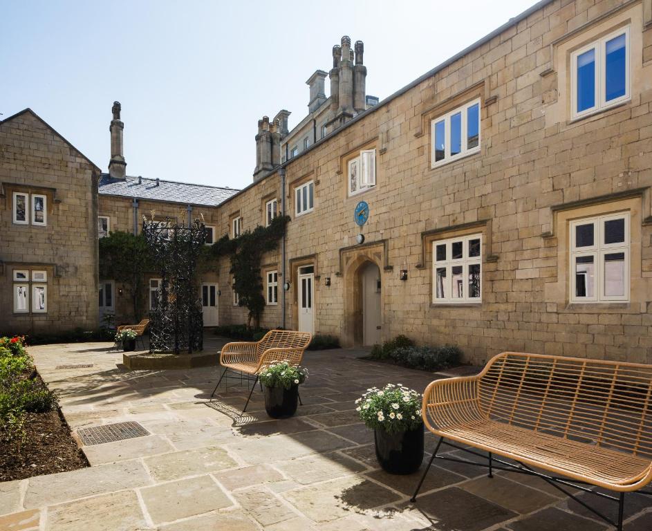 a group of benches in front of a building at Hiding Space - St Catherine's Hospital Apartments in Bath