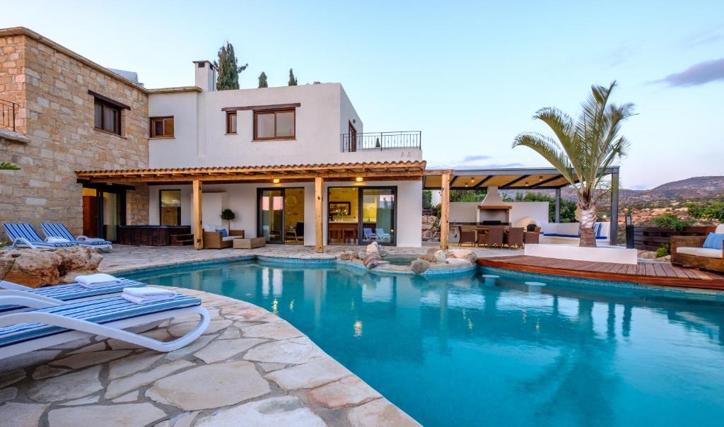 a house with a swimming pool in front of a house at Villa Palati in Peyia