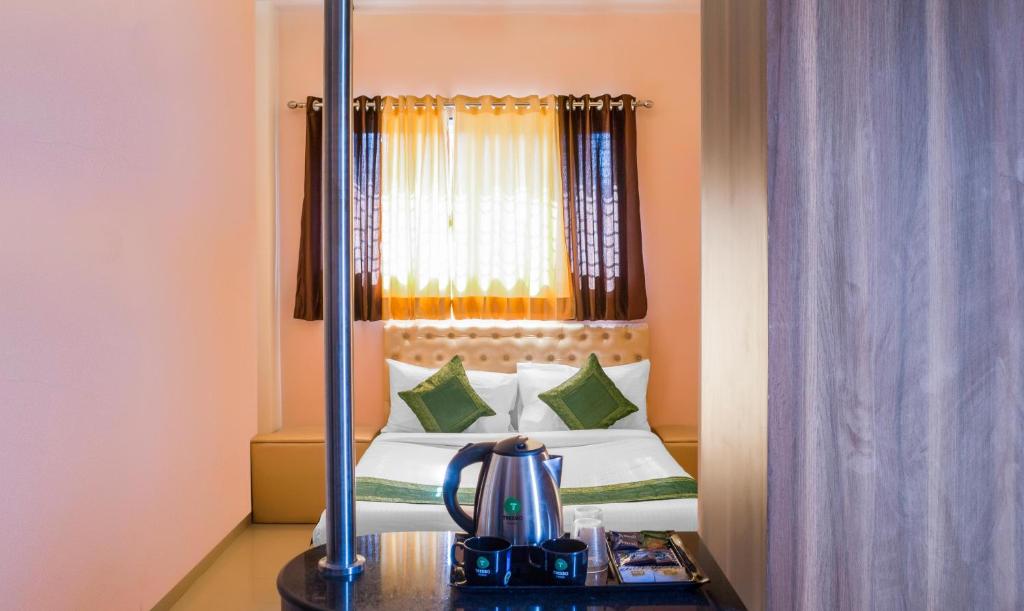 a hotel room with a bed and a mirror at Treebo Trend Naunidh Suites in Pune