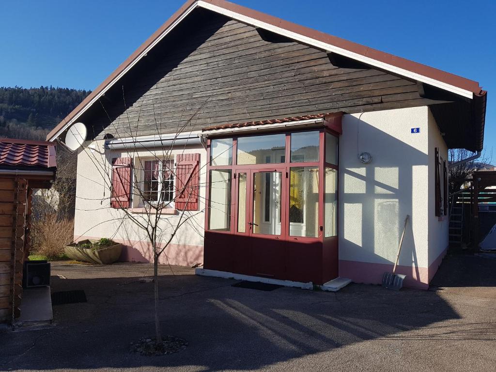 a small house with a red and white door at La petite chaumiere in Saint-Maurice-sur-Moselle