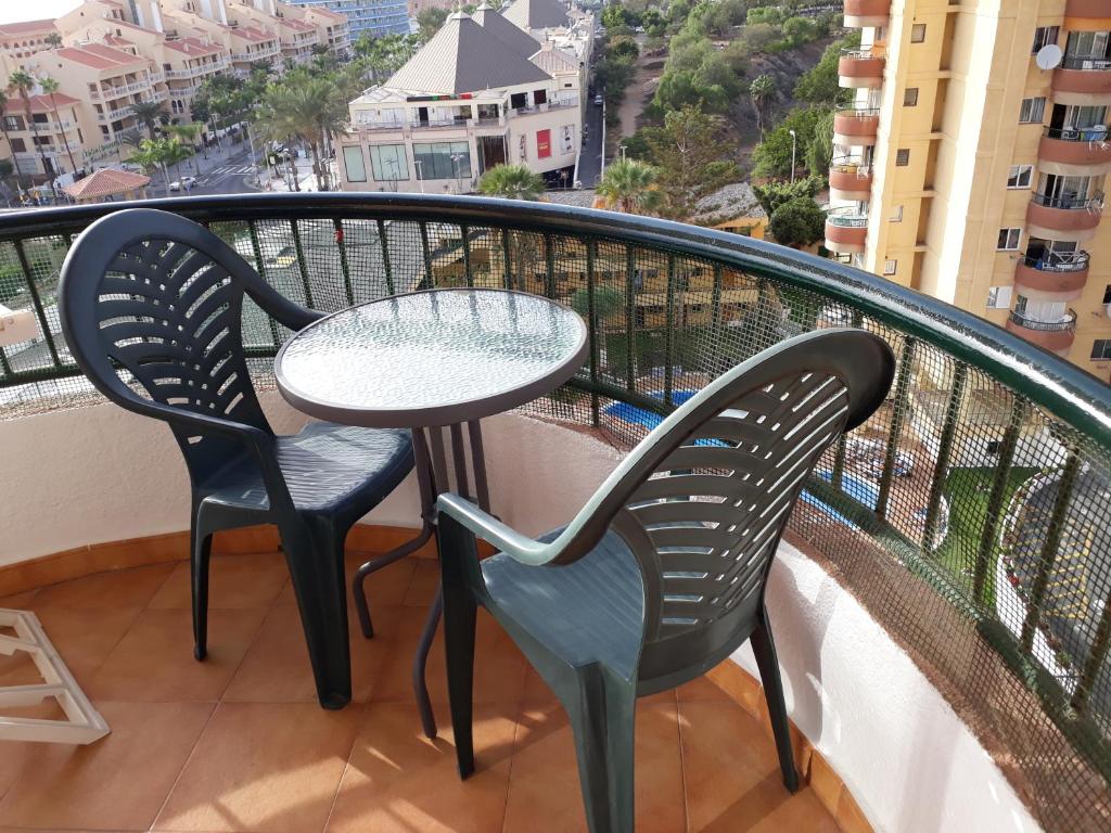 a table and two chairs on a balcony with a view at Torres del Sol Playa de Las Vistas FREE WIFI in Playa de las Americas