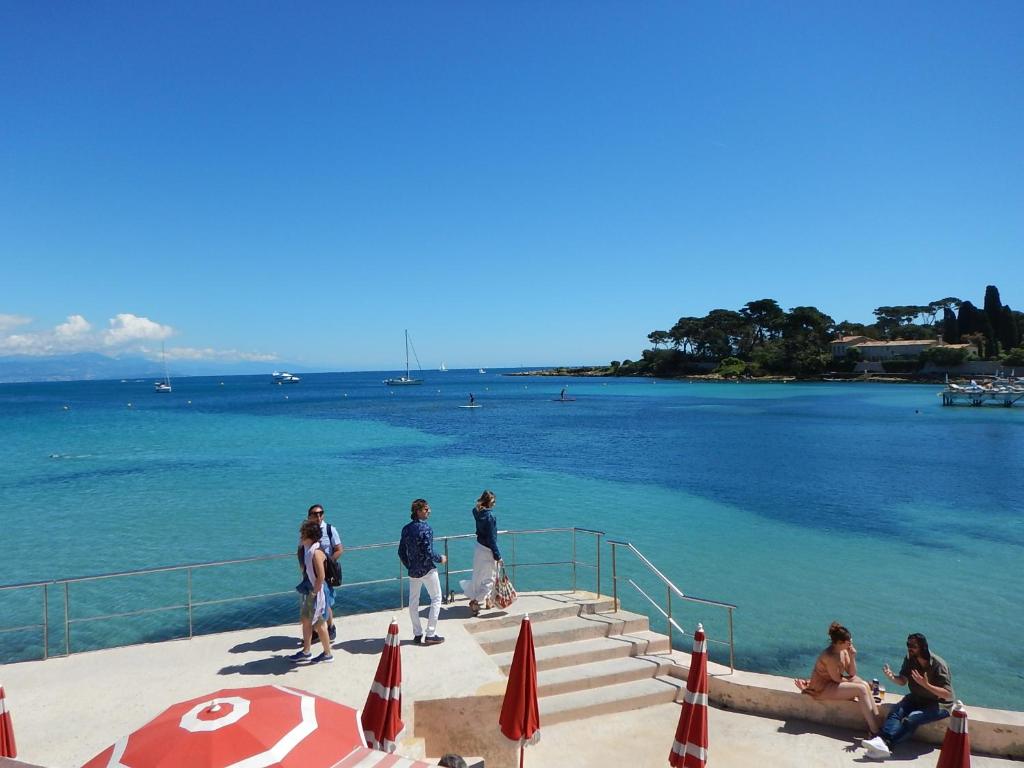 a group of people walking down the stairs to the water at Hotel Miramar- Cap d'Antibes - La Garoupe plage in Antibes