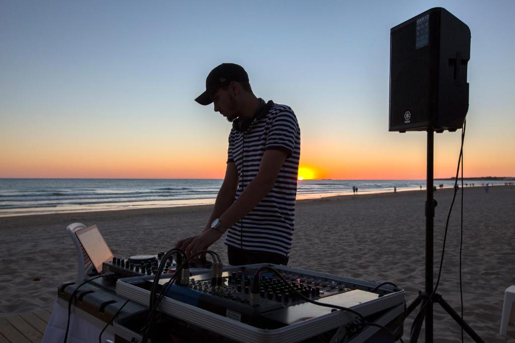 a man standing on the beach with a radio on the beach at Hipotels Barrosa Park in Chiclana de la Frontera