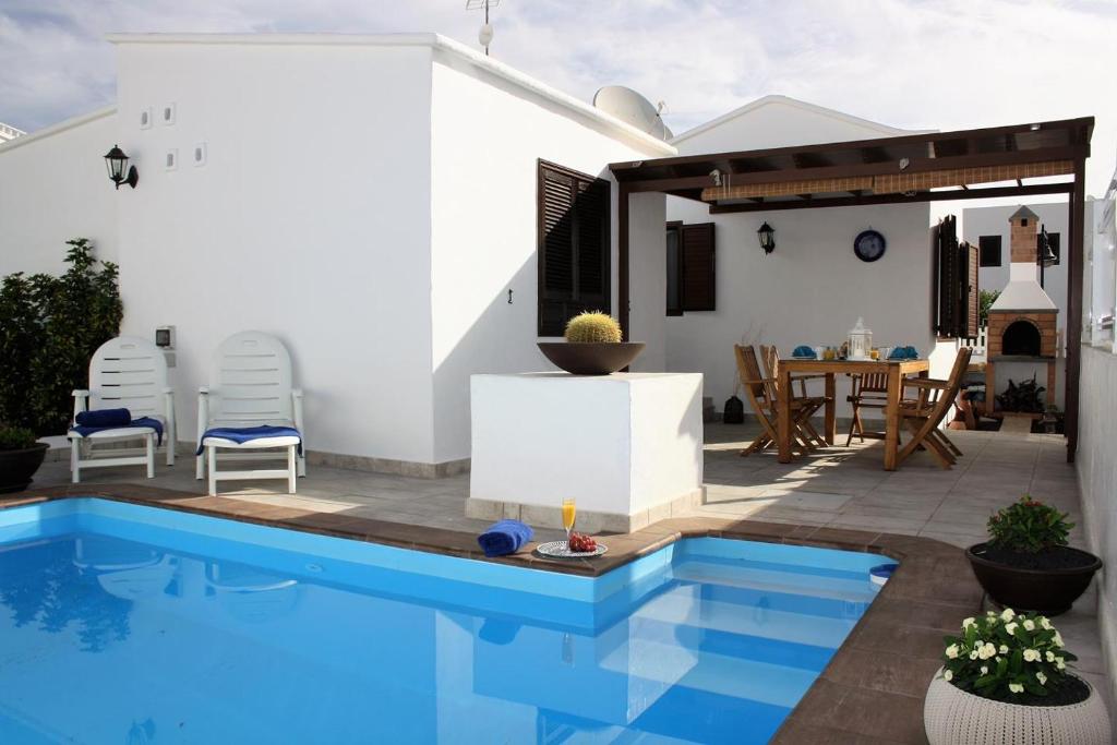 a house with a swimming pool and a patio at Villa Corona Roses in Puerto del Carmen
