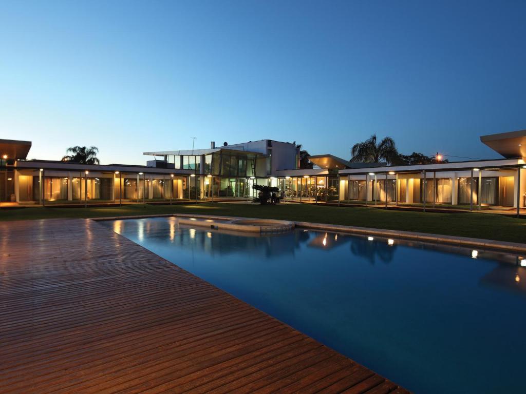 a swimming pool in front of a building at night at Hotel Camberland in Pilar