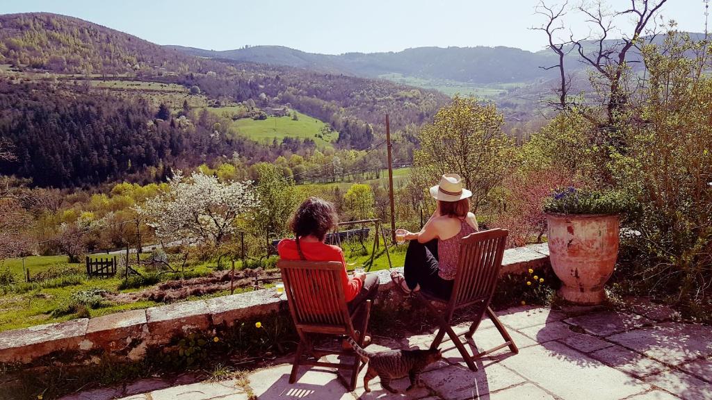 Dos mujeres sentadas en sillas con vistas a un valle en La Rivoire, en Saint-Julien-Molin-Molette
