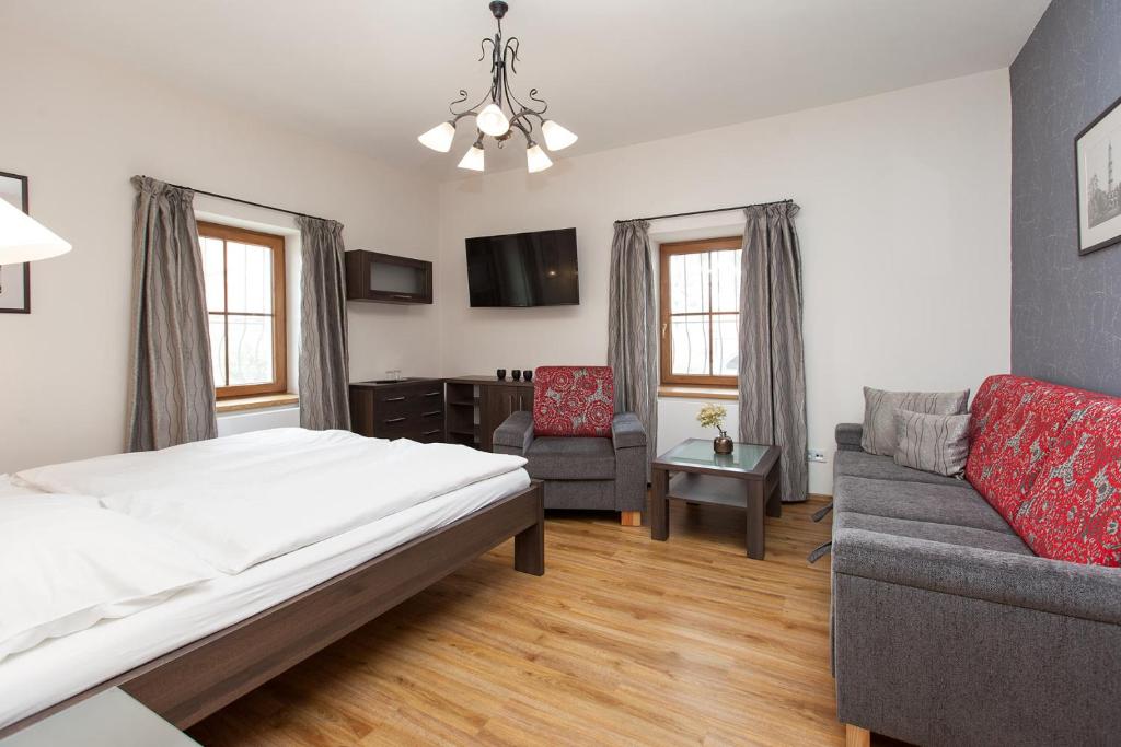 1 dormitorio con 1 cama, 1 sofá y 1 silla en Penzion Onyx, en Lednice