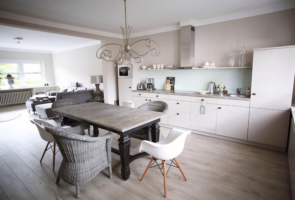 a kitchen and dining room with a wooden table and chairs at Quartier 23 in Nordhorn