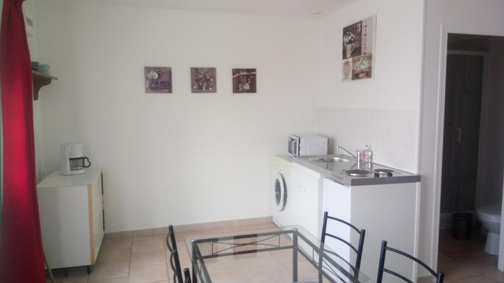 a kitchen with a sink and a table and chairs at Bellevue in Saint-Paterne-Racan