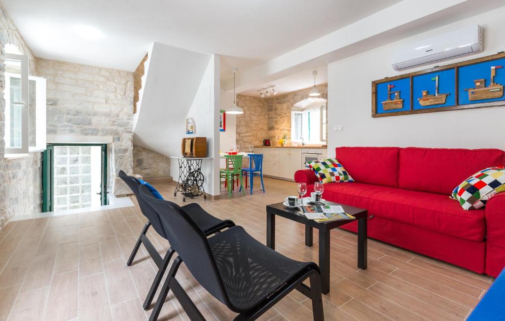 a living room with a red couch and chairs at Rustical 2 in Baška Voda