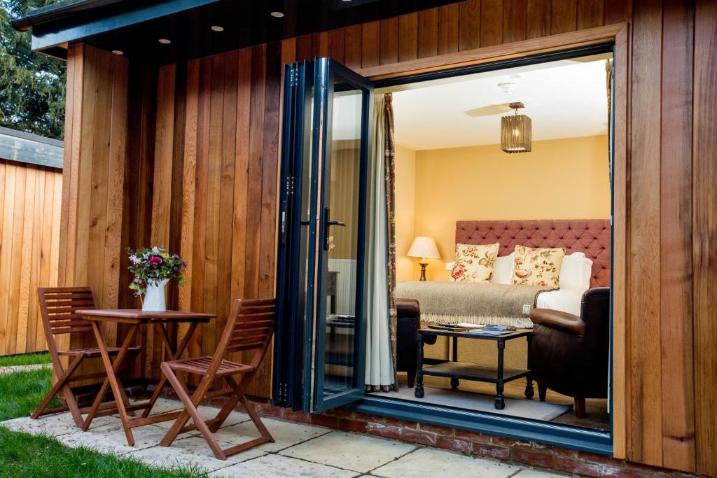 a patio with a table and chairs and a bedroom at The Thomas Lord in West Meon