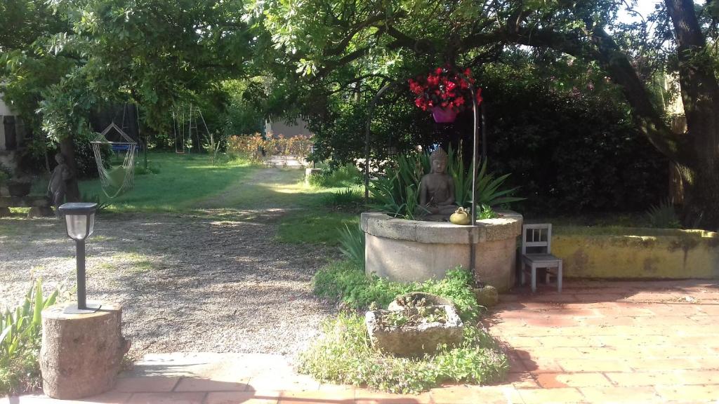 een park met een standbeeld en bloemen in een fontein bij Gîte de charme in Arles