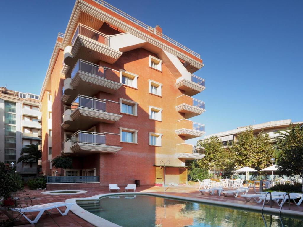 ein Gebäude mit einem Pool vor einem Gebäude in der Unterkunft Apartamentos Imperial in Salou