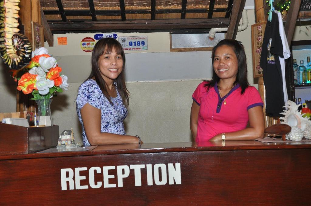 Due donne in piedi al bancone in un bar di SLAM'S Garden Dive Resort a Isola di Malapascua