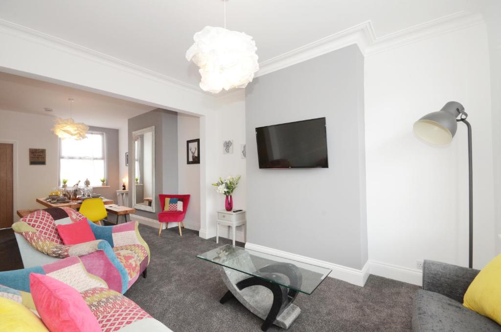 een woonkamer met een bank en een tv bij York Boutique House- spacious & stylish with free parking in York