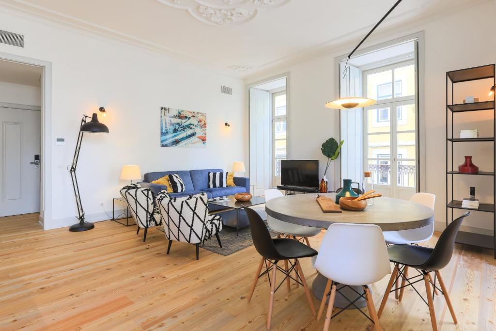 ein Wohnzimmer mit einem Tisch, Stühlen und einem Sofa in der Unterkunft Bacalhoeiros 99 - Beautiful and bright Apartment @ Baixa, Chiado in Lissabon