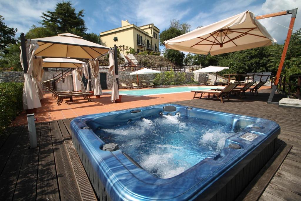 a hot tub with an umbrella next to a pool at Relais San Rocco in Sestri Levante