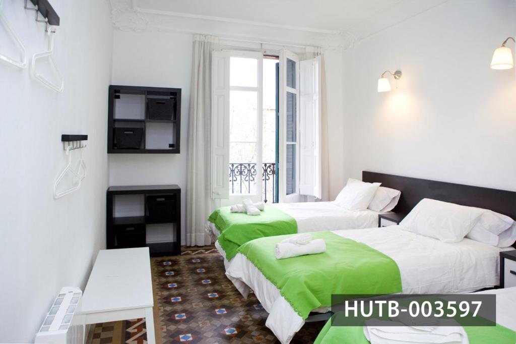 バルセロナにあるBig Apartment Barcelona Gran viaのホテルルーム ベッド2台&緑のシーツ付