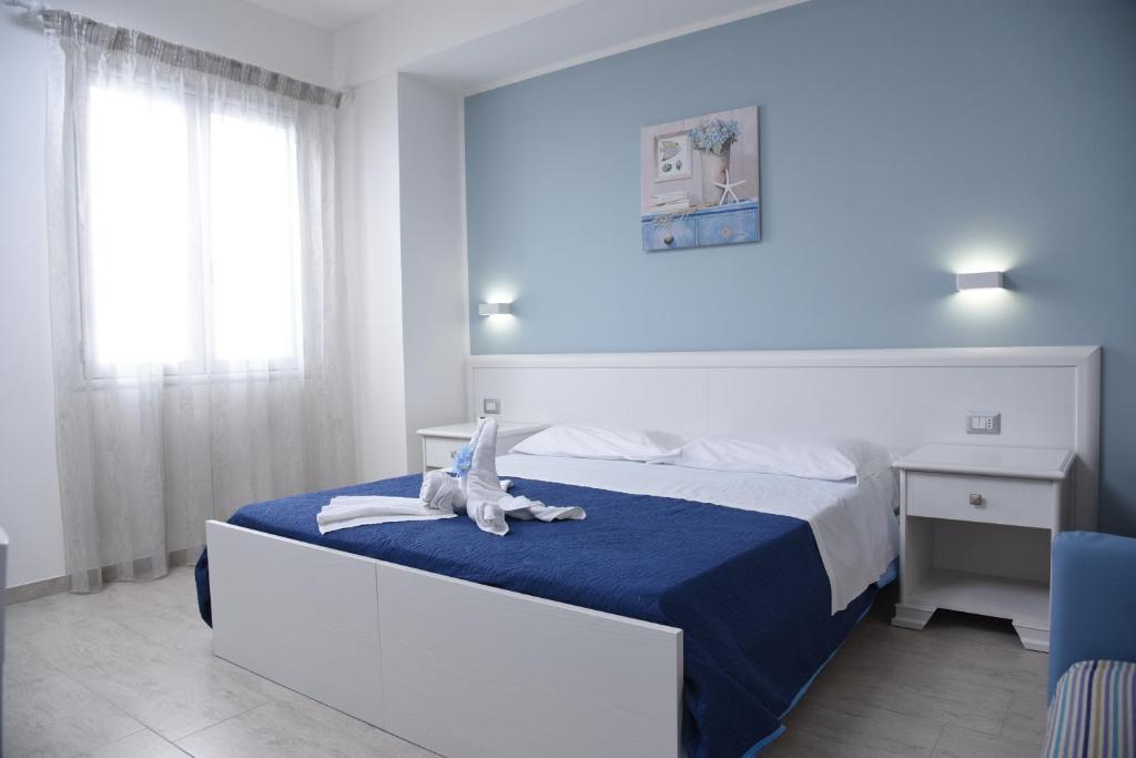 1 dormitorio con 1 cama con edredón azul en B&b VICTORIA en Porto Cesareo