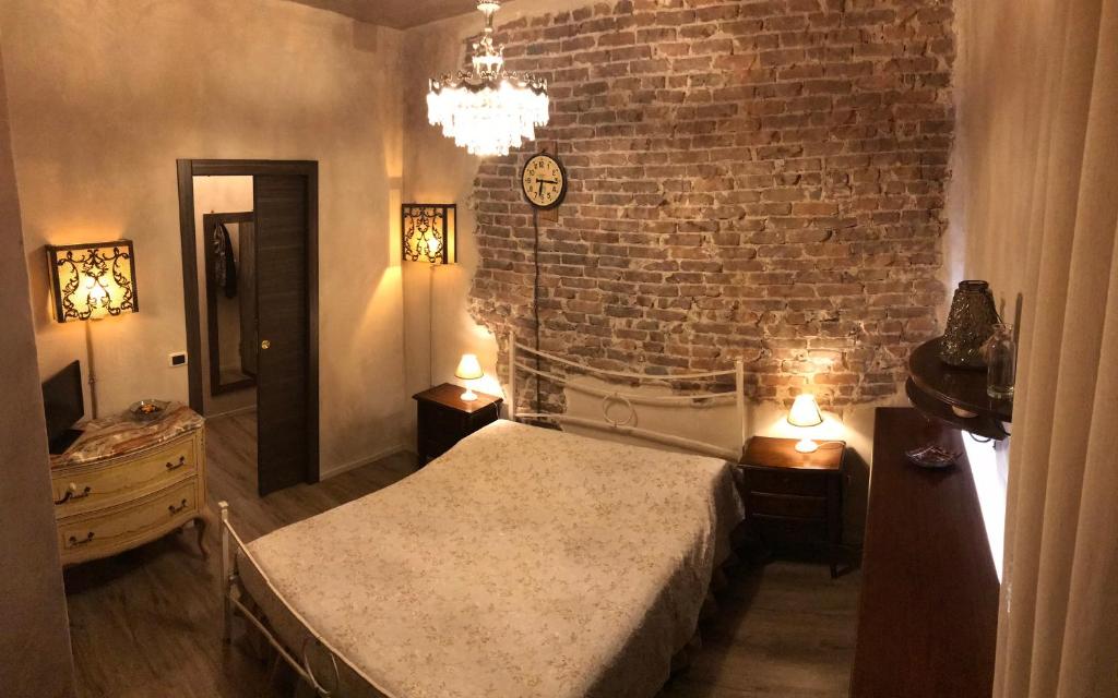 a bedroom with a bed and a brick wall at “La maison” nel cuore di Genova in Genoa