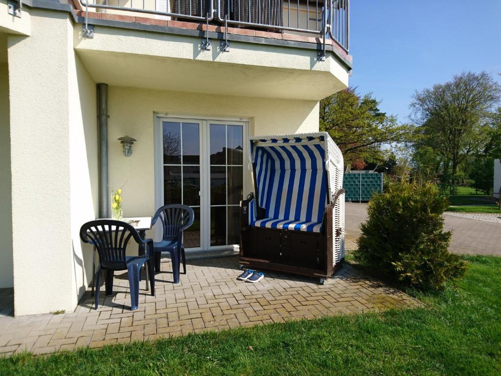 two chairs and a table in front of a house at Kumm Wedder in Insel Poel