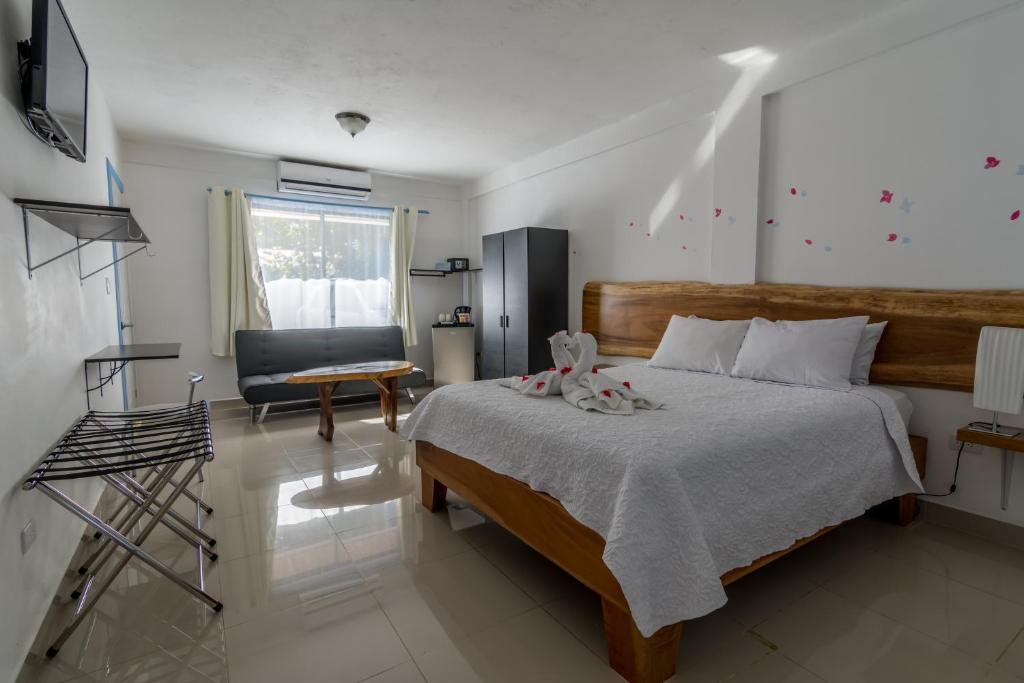 a bedroom with a bed and a desk and a chair at Boutique Hotel IBIZA in Jacó