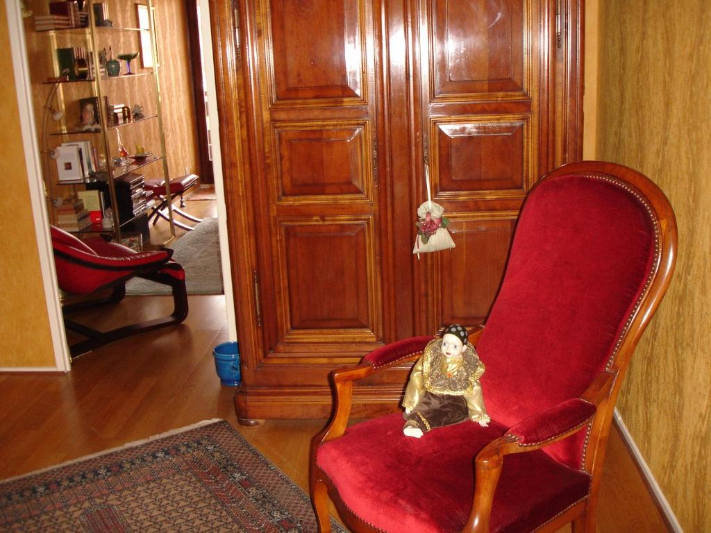a doll sitting in a red chair in a room at Patio in Colmar