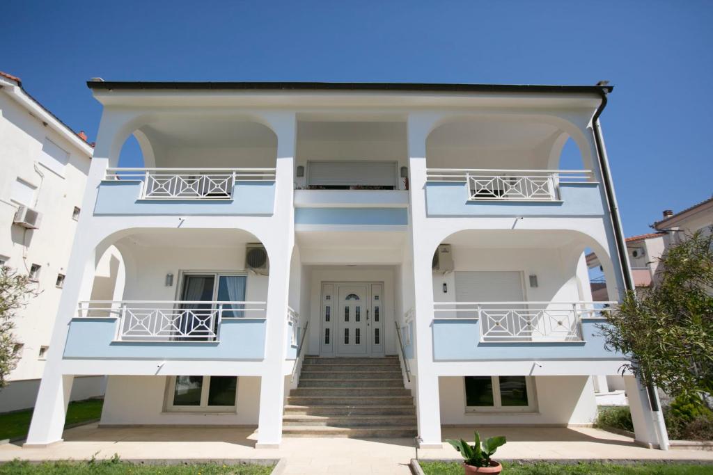 a large white house with two balconies at Susanna Apartments in Keramoti