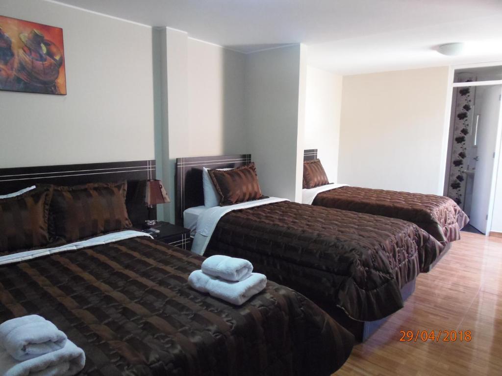 um quarto de hotel com duas camas com toalhas em B&B Cusing Wasi em Lima