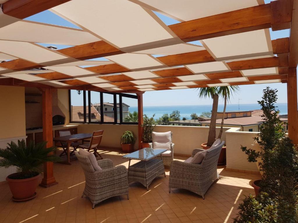 patio con sedie in vimini e soffitto in legno di B&B e Casa Vacanza al Castello a Roccella Ionica
