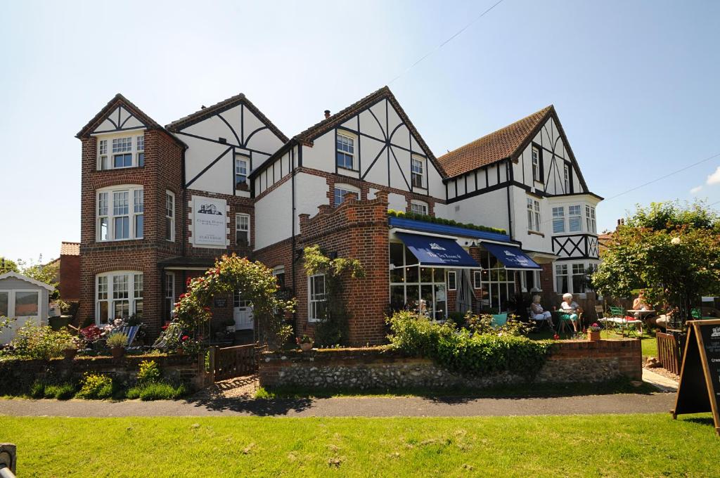 a large brick building with people sitting outside of it at Corner House Bed & Breakfast in West Runton