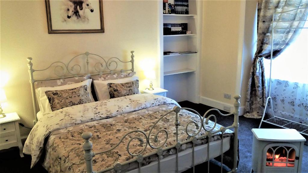 ein Schlafzimmer mit einem Bett und einem Bücherregal in der Unterkunft Cozy Central Apartment in Inverness