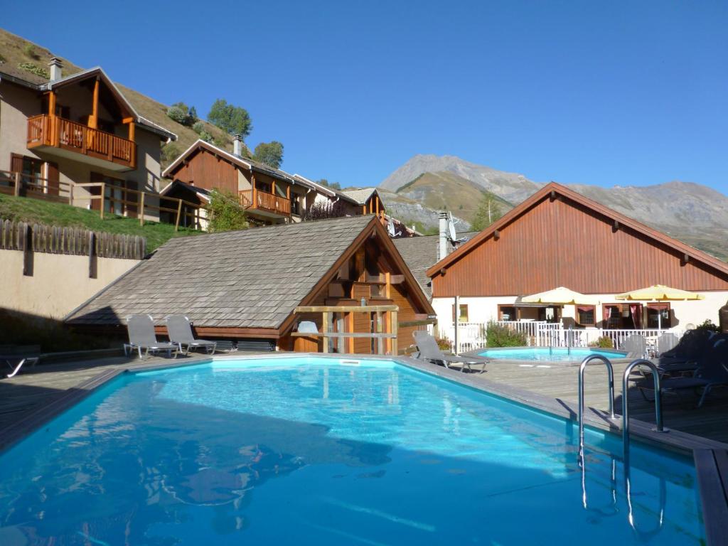 a large swimming pool in front of a house at Cosy Appart'Hotel - Panoramic Village - La Grave in La Grave