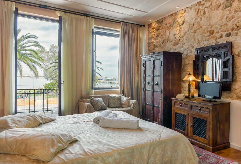 een slaapkamer met een bed en een tv en een bank bij Elois Suites in Rethimnon