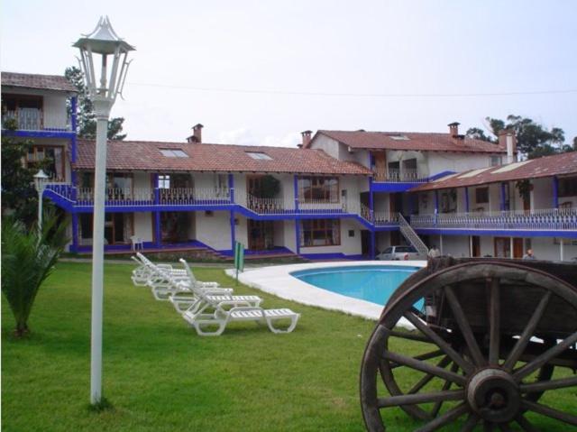 un gran edificio con piscina, sillas y cañón en Hotel Bella Vista, en Huasca de Ocampo