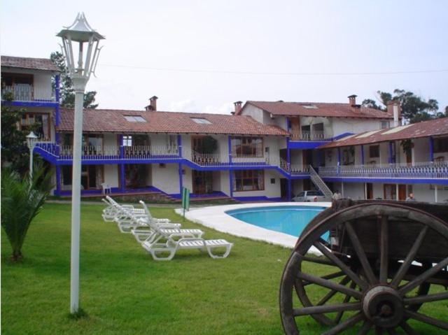 a large building with a pool and chairs and a cannon at Hotel Bella Vista in Huasca de Ocampo