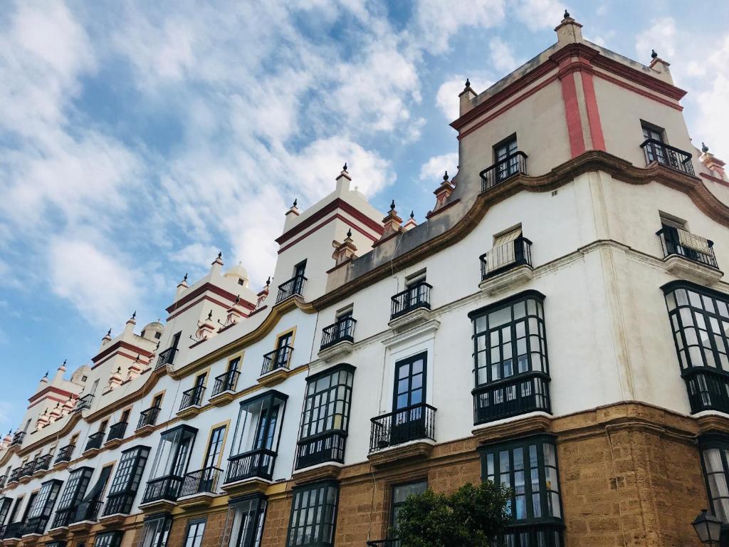 カディスにあるCasa de las Cinco Torresの窓と空のある白い大きな建物