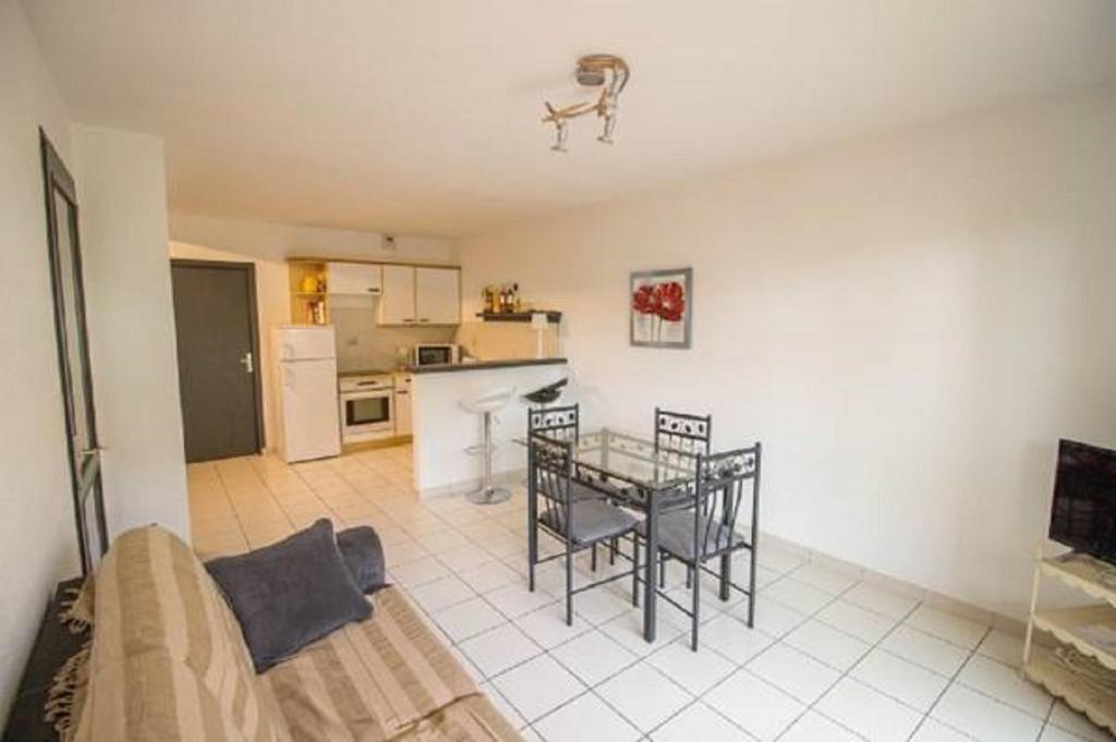 ein Wohnzimmer mit einem Tisch und einer Küche in der Unterkunft L'embarcadère in Mimizan-Plage