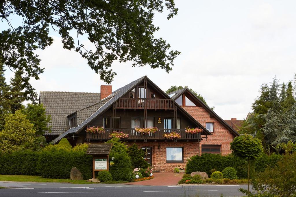 a large brick house with a balcony at Landhaus Burs in Löningen