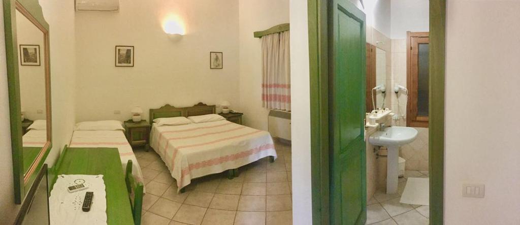 Sant Efisio في لوتْسوراي: غرفة نوم بسريرين ومغسلة ومرآة