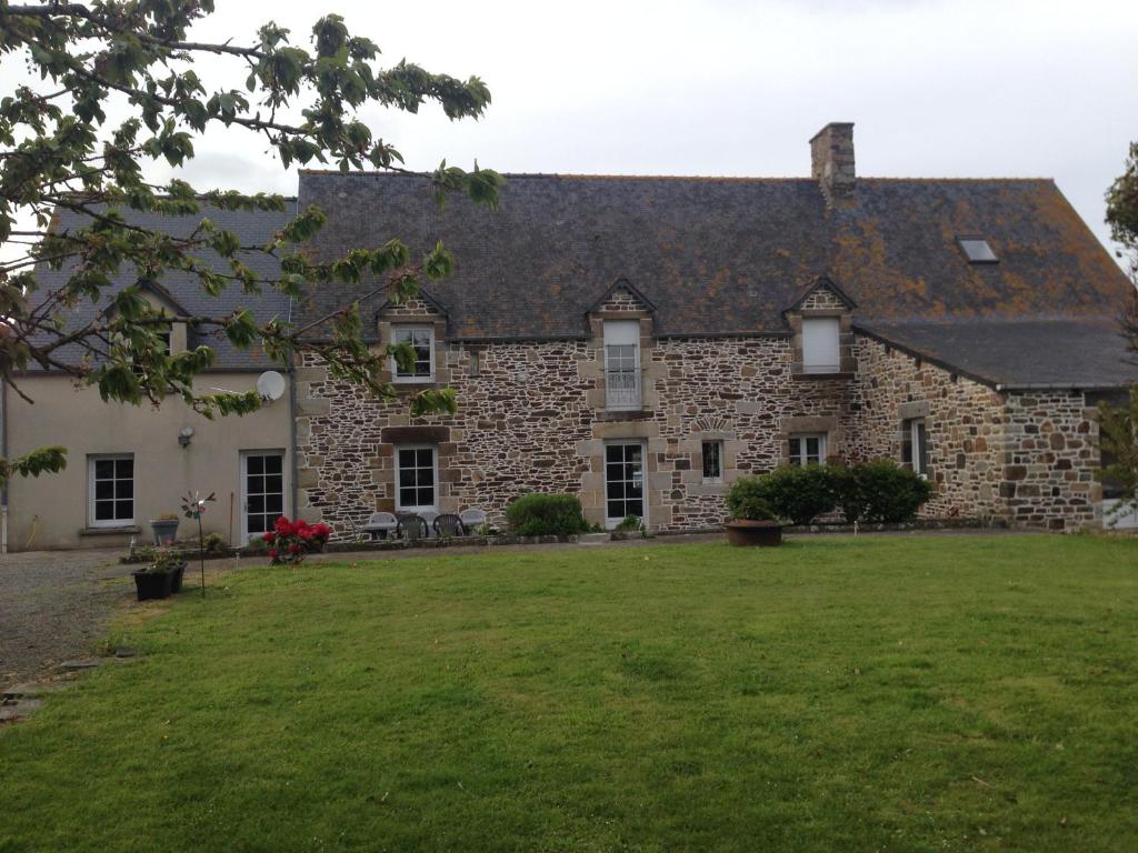 una grande casa in pietra con un ampio cortile di Le Manoir de la Pichardière a Cherrueix